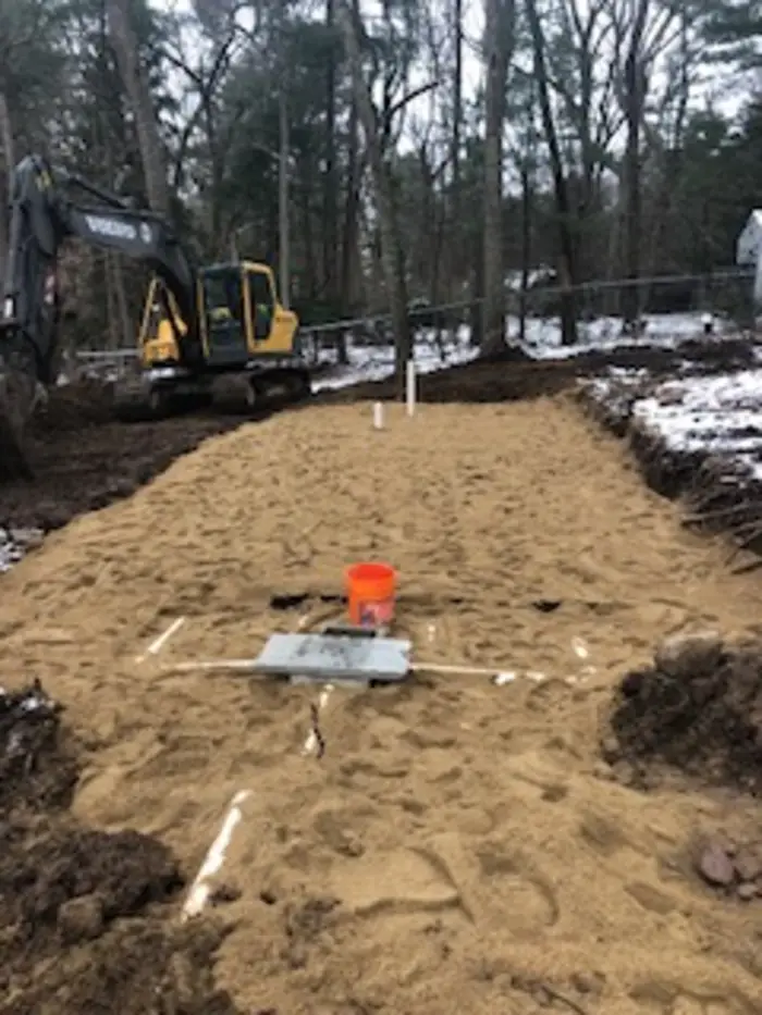 Sand-filled leaching field with excavator behind