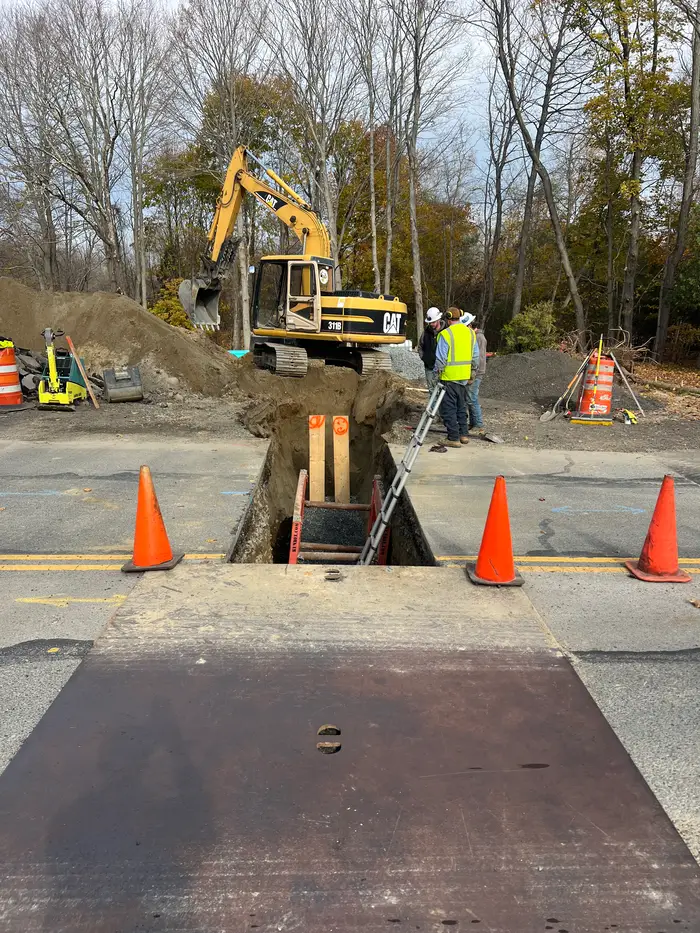 Crew and excavator working in a road trench